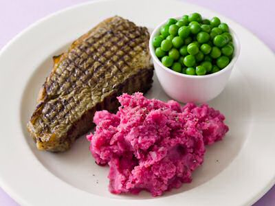 Een lekker bord rode bietenpuree met gegrilde steak en erwtjes